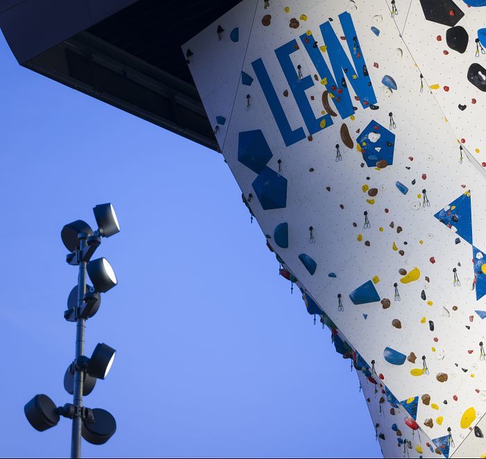 Illuminated climbing wall with LED spotlights enhancing holds and ensuring safety at night.