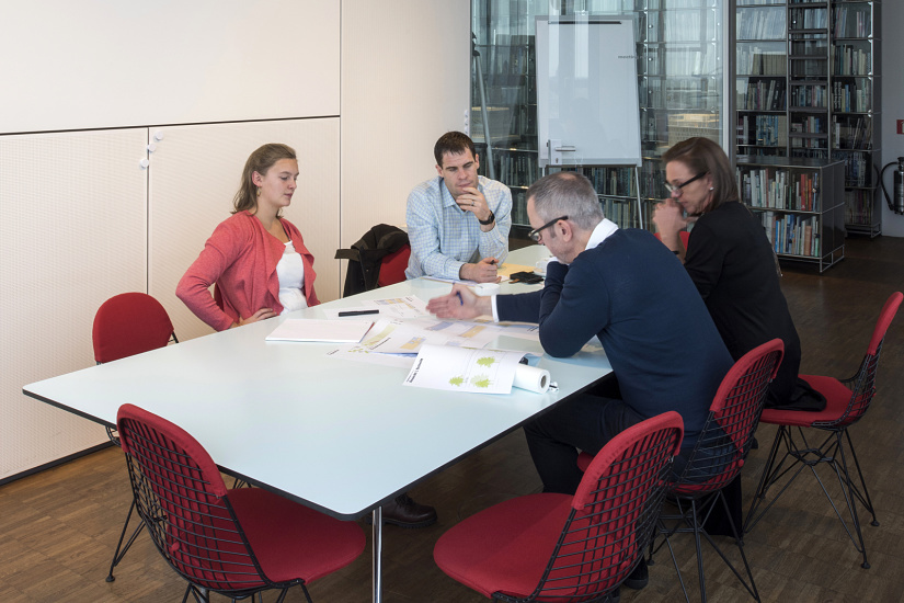 Ingenhoven Architects office: Team discusses plans under ERCO Optec spotlights, providing flexible lighting.