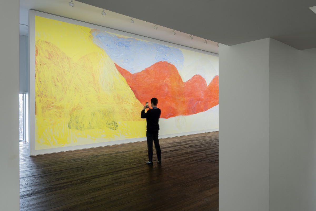 Visitor photographs art in Johyun Gallery, illuminated by ERCO spotlights.