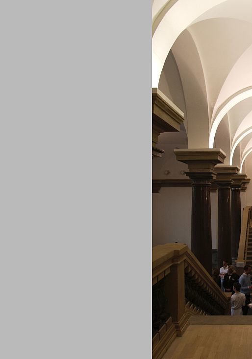 Interior of K21 Art Gallery featuring stairs, columns, and visitors, illuminated by ERCO lighting.