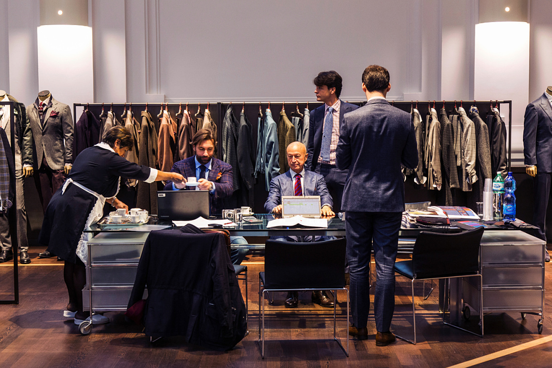 Kiton store in Milan: Customers being served coffee while viewing suits.