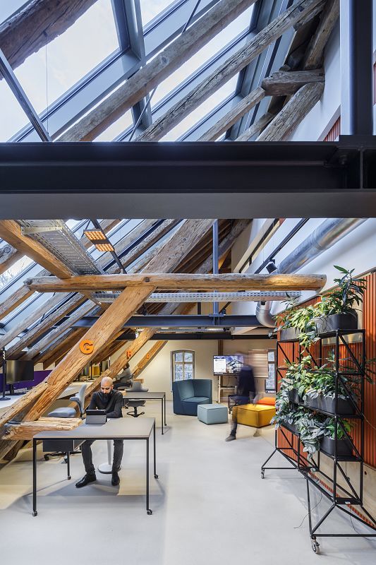 Koppenmühle Darmstadt office with ERCO lighting under historic timber structure.