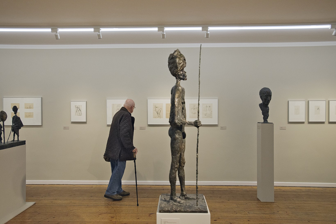 Kunsthalle Rostock: Visitor views sculpture under Pollux spotlights. Accent lighting in the museum.