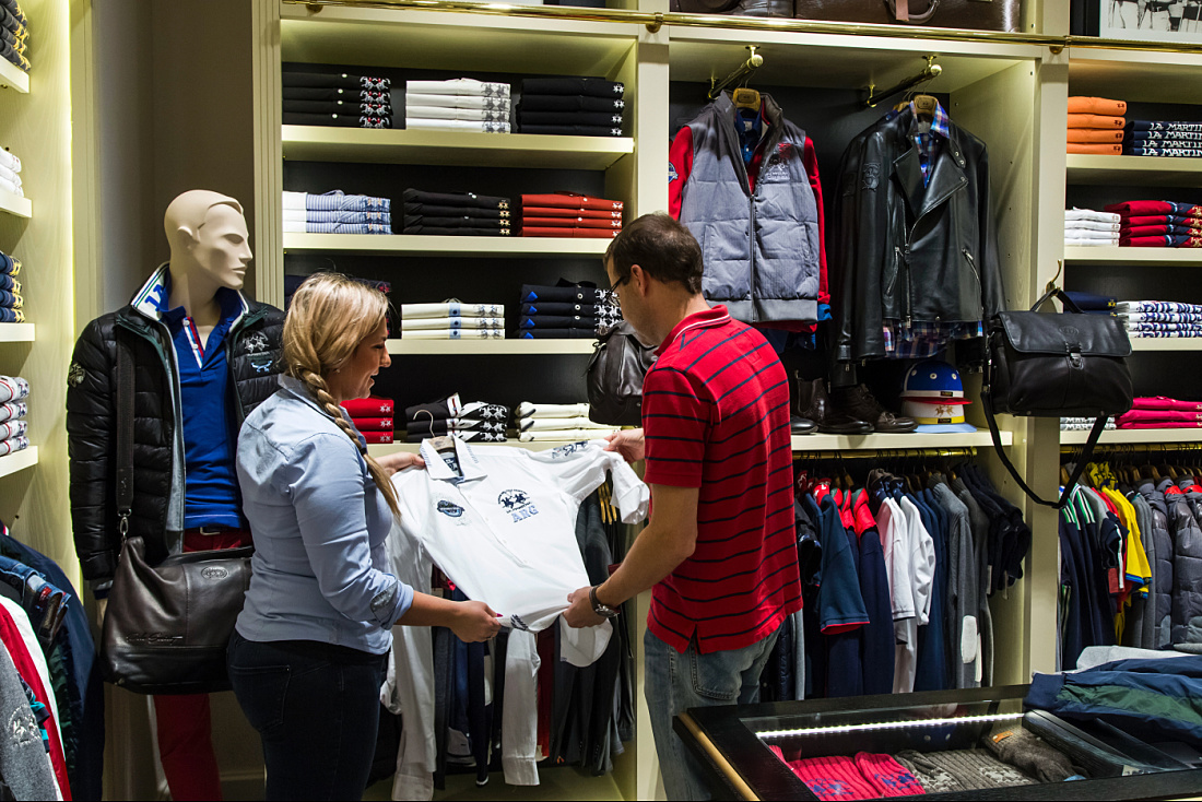 Customers select a La Martina polo shirt in a boutique lit by ERCO LEDs.