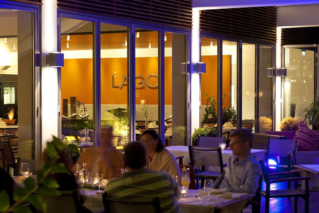 Illuminated LAGO Hotel restaurant in Ulm, featuring ERCO outdoor lighting for an inviting ambiance.