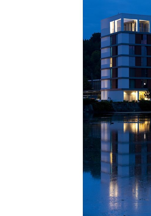 LAGO Hotel in Ulm, a stylish building with soft lighting reflected in the lake.