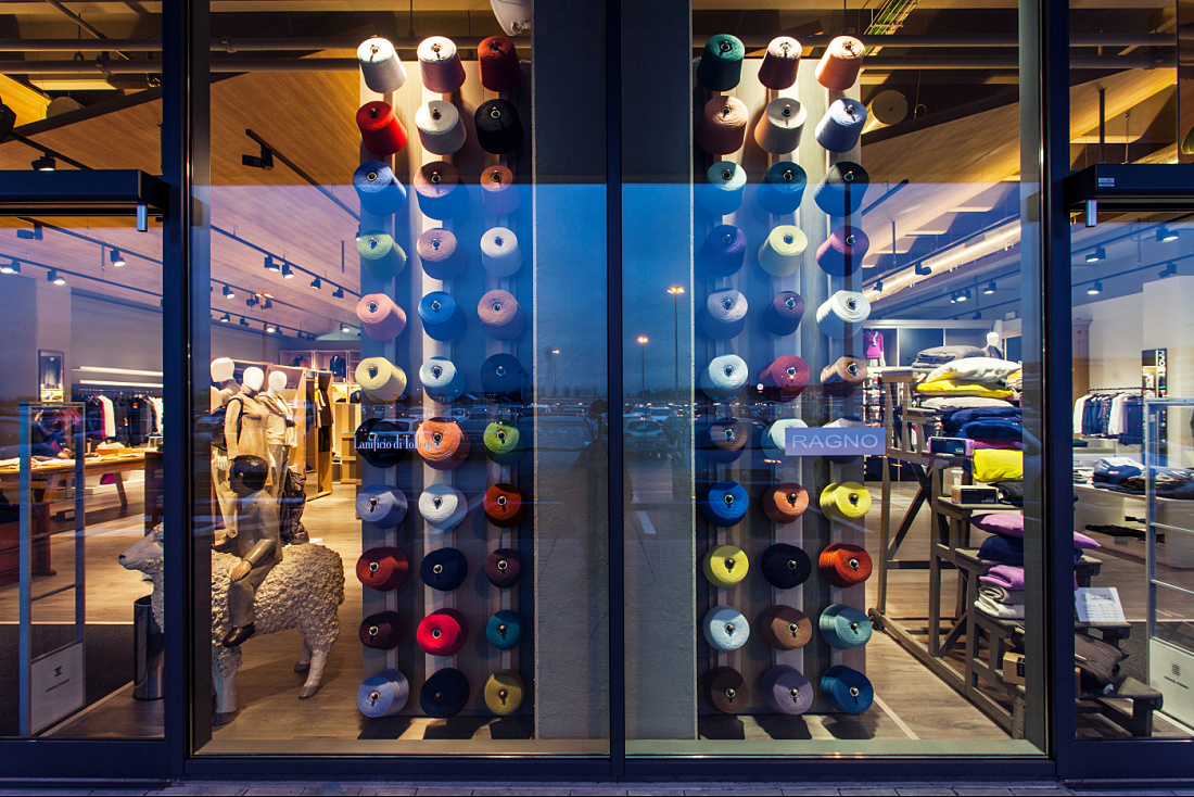 Lanificio di Tollegno/Ragno store window featuring colorful yarn spools and ERCO Optec spotlights.