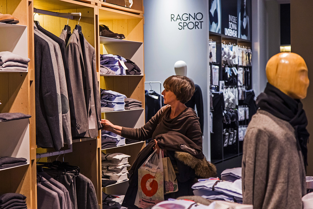 Customer selecting clothing at Lanificio di Tollegno/Ragno concept store in Milan, lit by ERCO Optec spotlights.