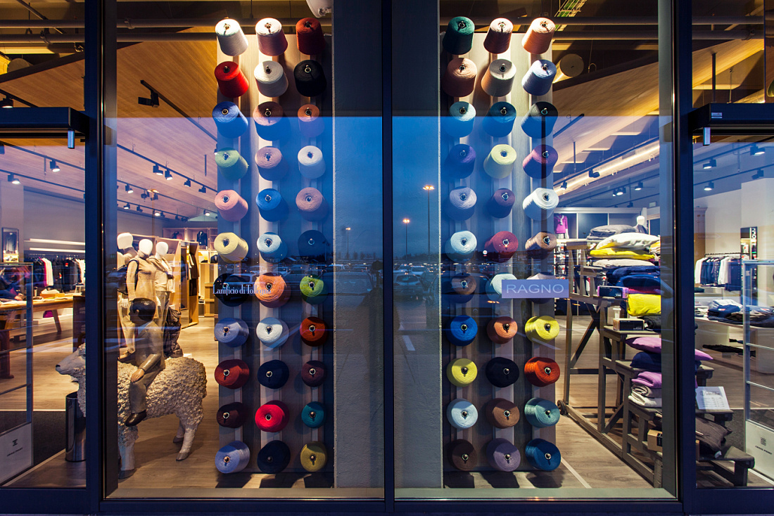 Lanificio di Tollegno/Ragno store window featuring colorful yarn spools and ERCO Optec spotlights.