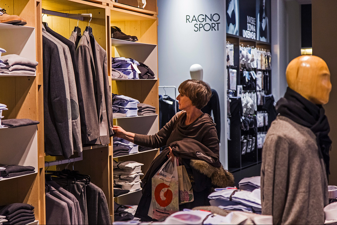 Customer selecting clothing at Lanificio di Tollegno/Ragno concept store in Milan, lit by ERCO Optec spotlights.
