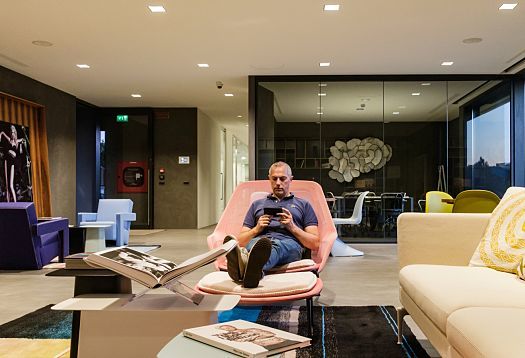 Man relaxing in Le Silla HQ lounge area with ERCO lighting, modern design.