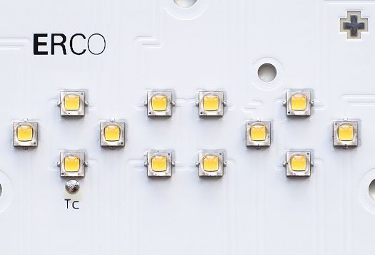 Close-up of ERCO SMD LEDs on a circuit board, emitting light.