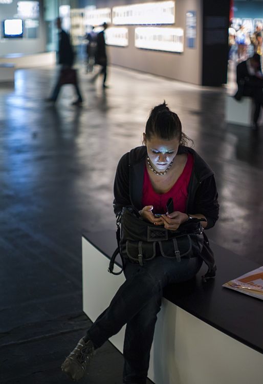 Visitor at Photokina 2012 with ERCO LED lighting using a smartphone.