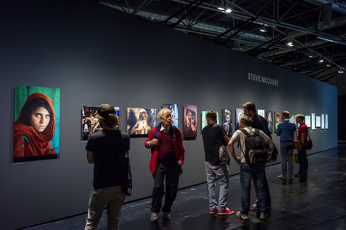 Visitors view Steve McCurrys photo exhibit, illuminated by ERCO Light Board LED spotlights at Photokina 2012.