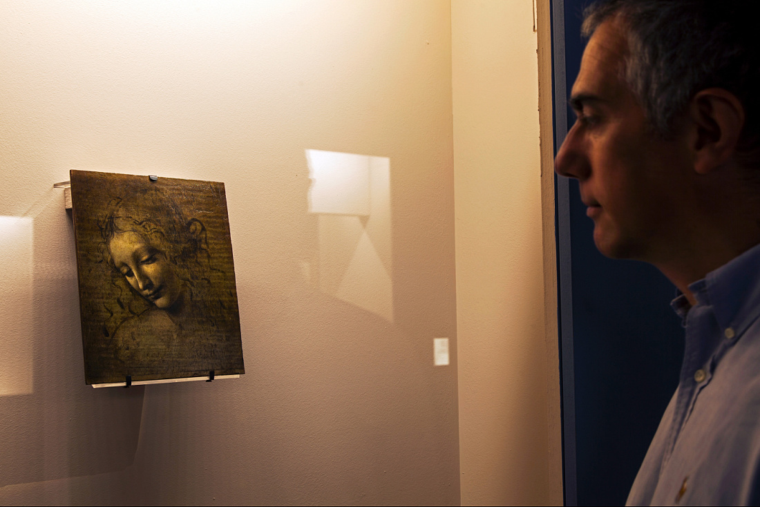 A visitor views a Leonardo da Vinci painting, illuminated by ERCO LED spotlights, at an exhibition.