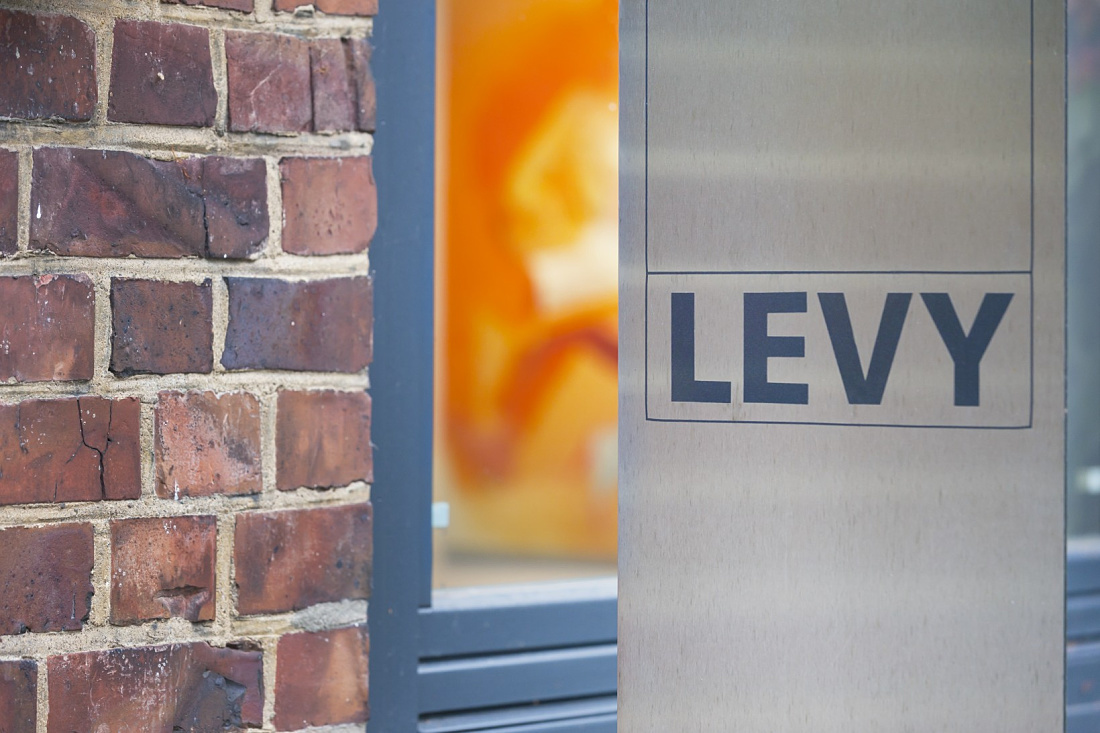 Levy Gallery entrance with brick wall and ERCO lighting.