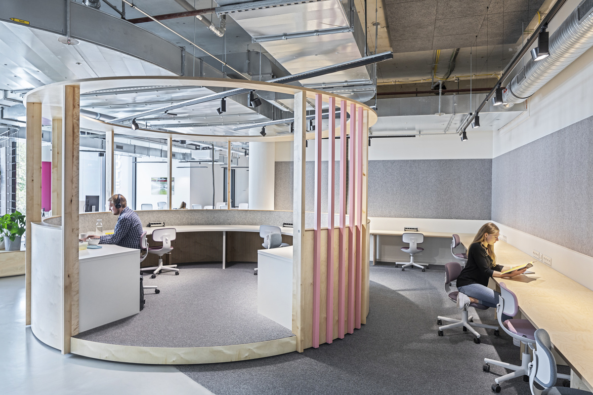 Flexible ERCO LED lighting with Jilly downlights and Parscan spotlights in a modern co-working space.