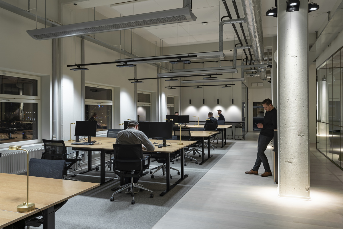 ERCO LED track lighting in a flexible co-working space, creating adaptable workspaces with energy-efficient illumination.
