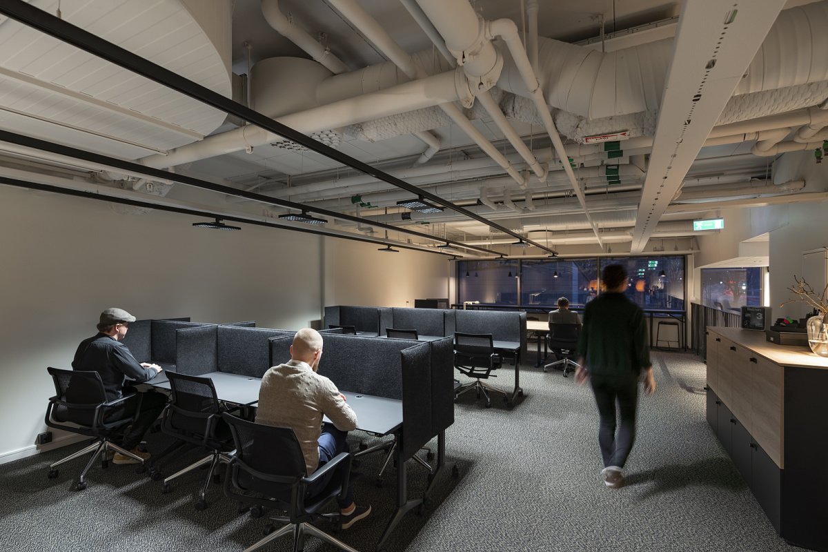 ERCO LED track downlights illuminate a flexible co-working space, adapting to user needs for effective work.