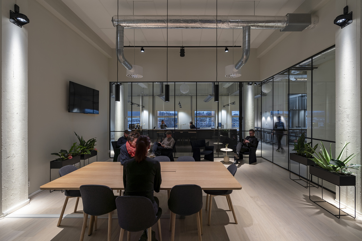Flexible ERCO LED lighting in a modern co-working space, featuring Jilly downlights for adaptable illumination.