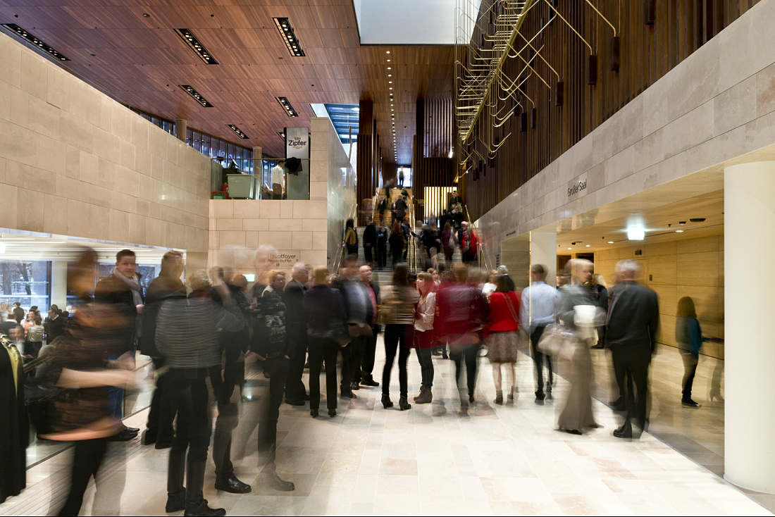 Linz Music Theatre foyer with ERCO lighting and blurred crowd.