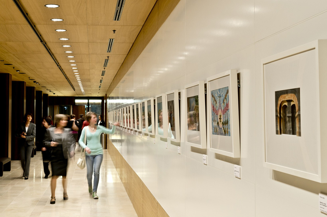 Visitors view art in the illuminated foyer of Linz Music Theatre, accented by ERCO lighting.