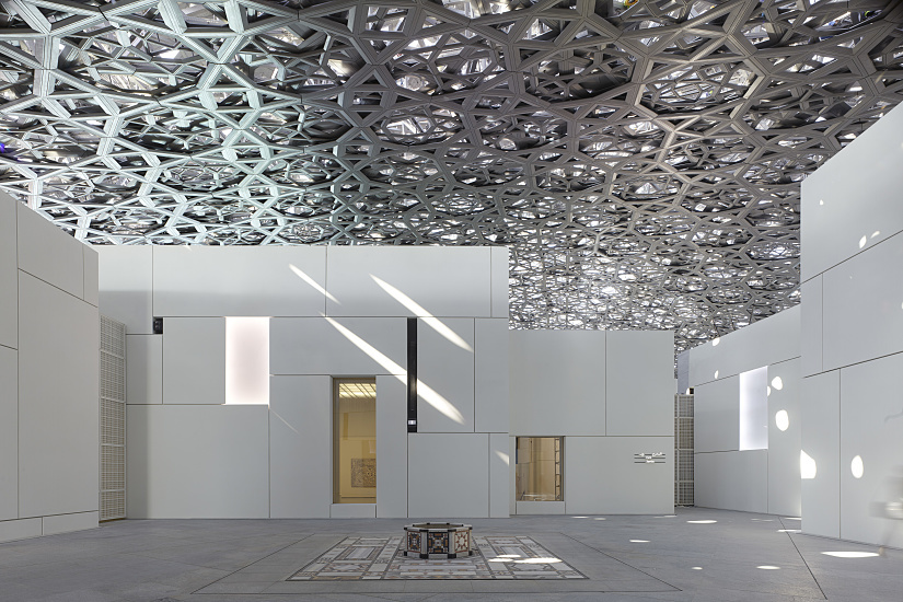 Louvre Abu Dhabi's architecture featuring ERCO LED lighting under the iconic dome, creating a play of light and shadow.