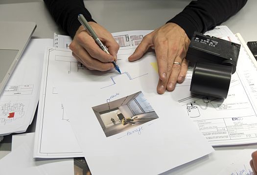 ERCO lighting design for Louvre Abu Dhabi: Architect sketching with LED lighting tools on the table.