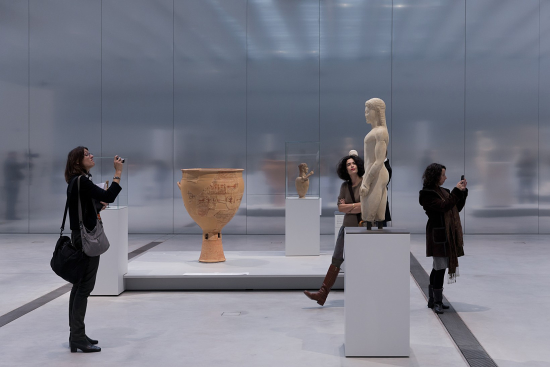Visitors admire ancient art at the Louvre-Lens, illuminated by ERCO LED lighting.