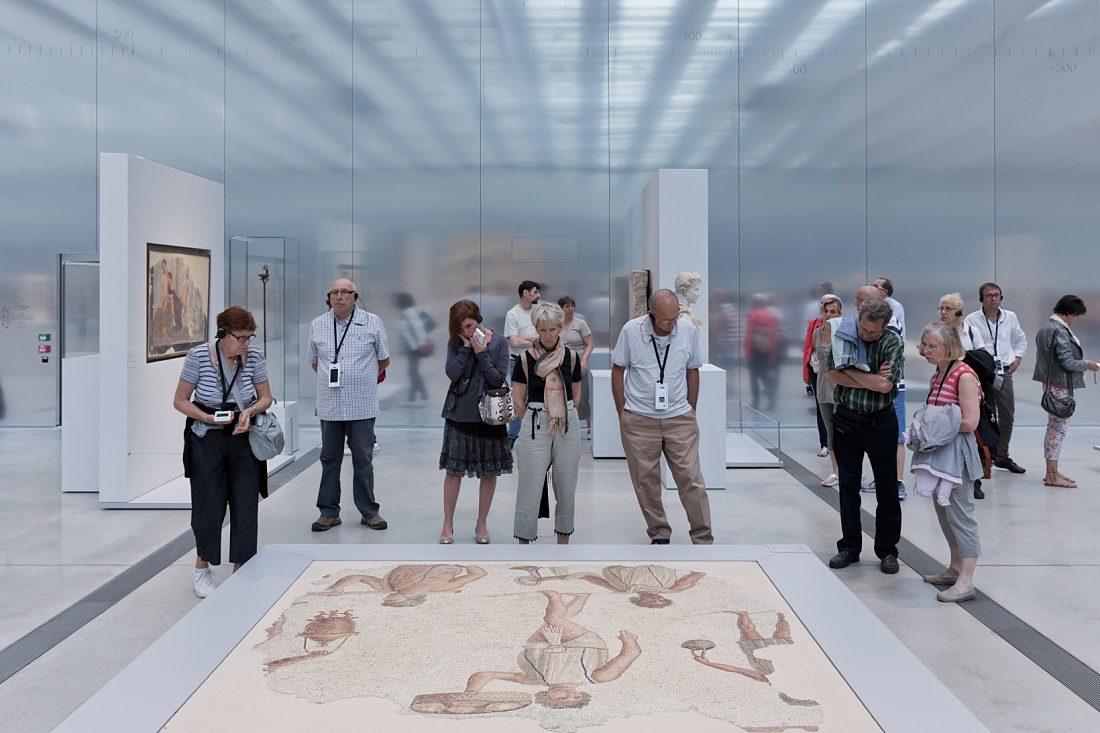 Visitors view a mosaic at the Louvre-Lens Museum, illuminated by ERCO LED lighting.