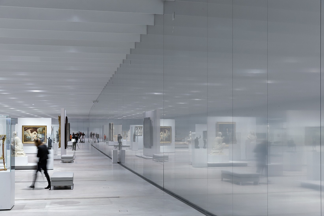 Interior of the Louvre Lens Museum featuring ERCO LED lighting and visitors.