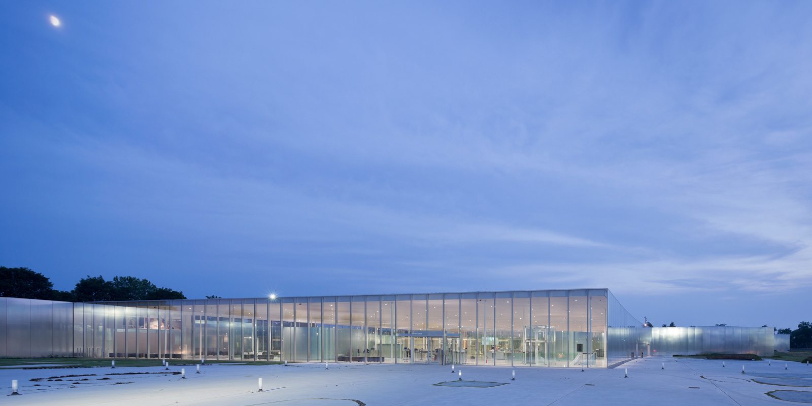 Louvre-Lens Museum at dusk, illuminated with ERCO LED lighting for a transparent, inviting ambiance.