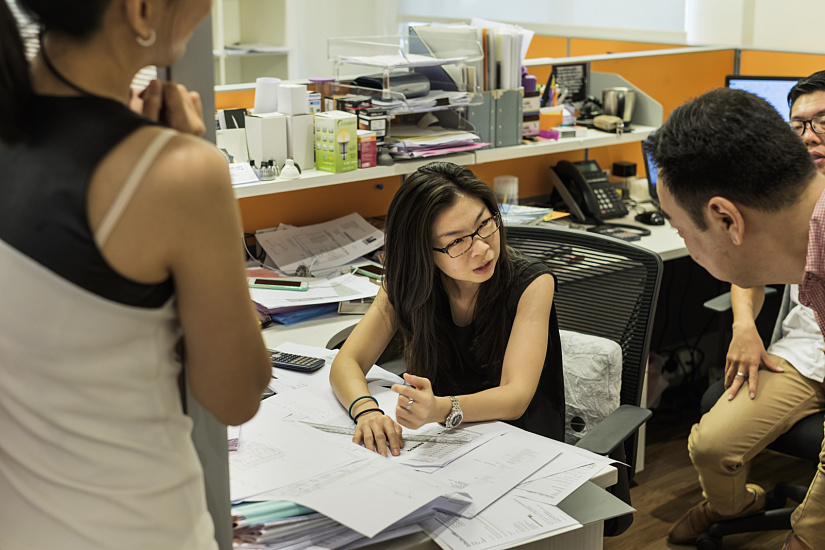 LuxLight Singapore office: Staff discussing lighting plans with ERCO LED fixtures.