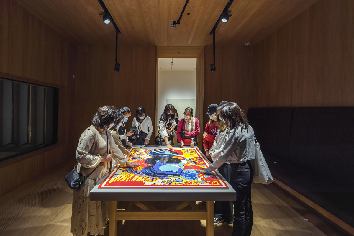 Visitors view artwork at M+ Museum, illuminated by ERCO spotlights, enhancing the dynamic museum lighting experience.