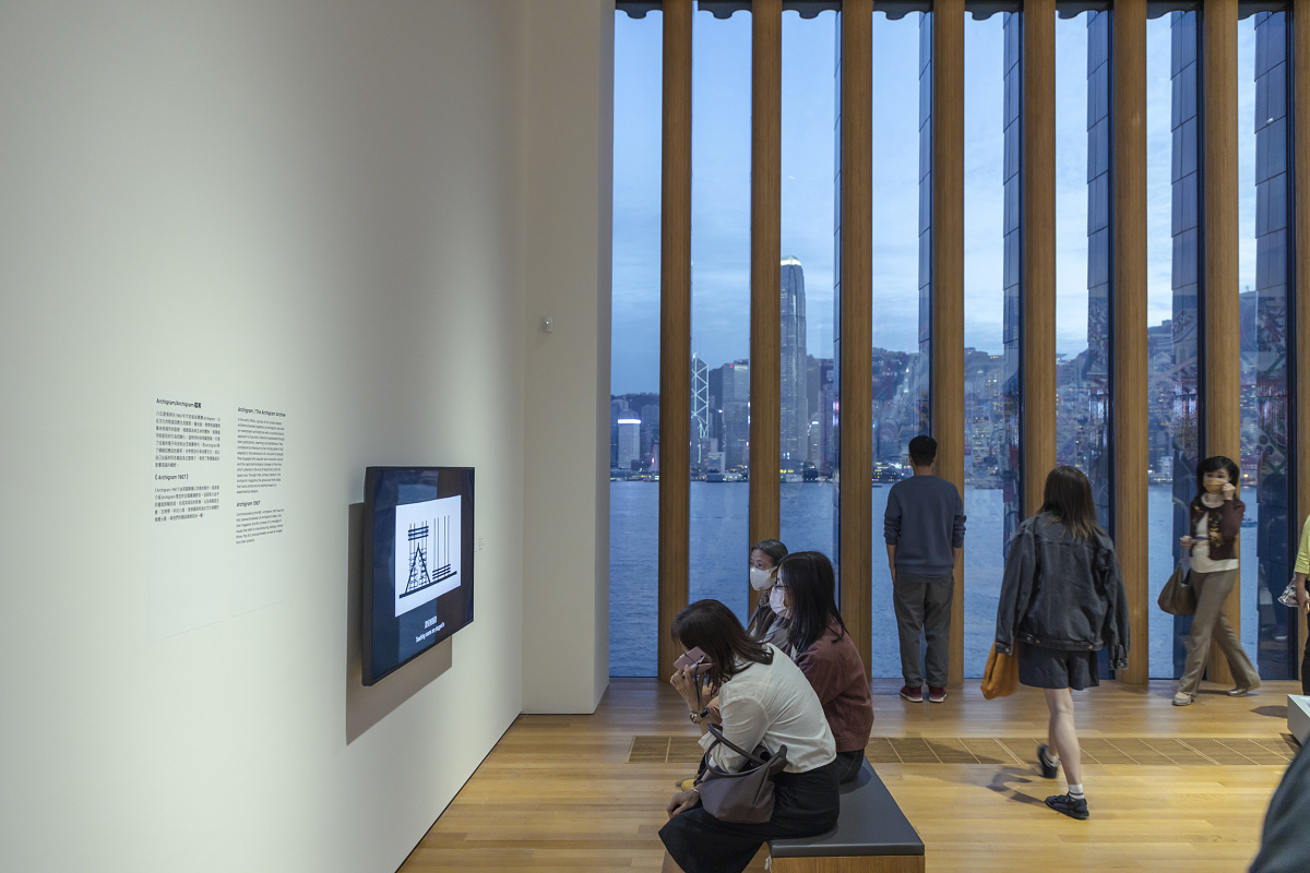 Visitors at the M+ Museum view art illuminated by ERCO spotlights, with a Hong Kong skyline backdrop.