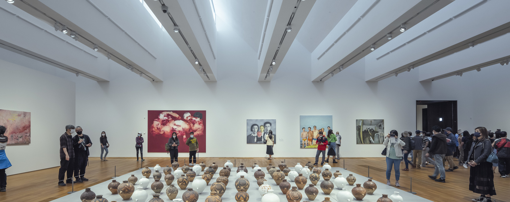 Visitors view art at M+ Museum, illuminated by ERCO track lighting and Parscan spotlights.