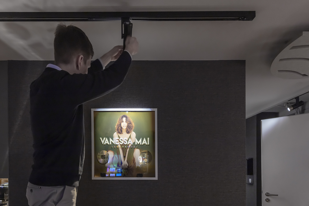 Installing an ERCO spotlight to accentuate a Vanessa Mai picture in the studio.