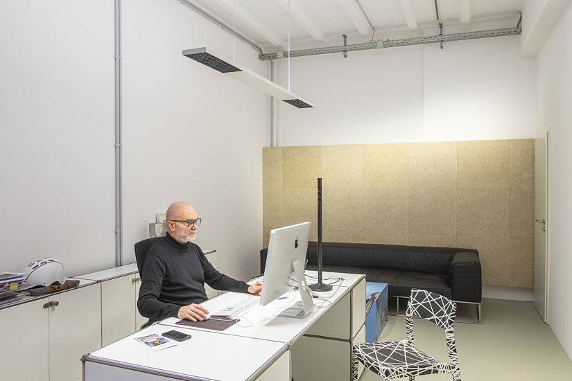 Man working in an office featuring ERCO Jilly downlights for flexible office lighting.