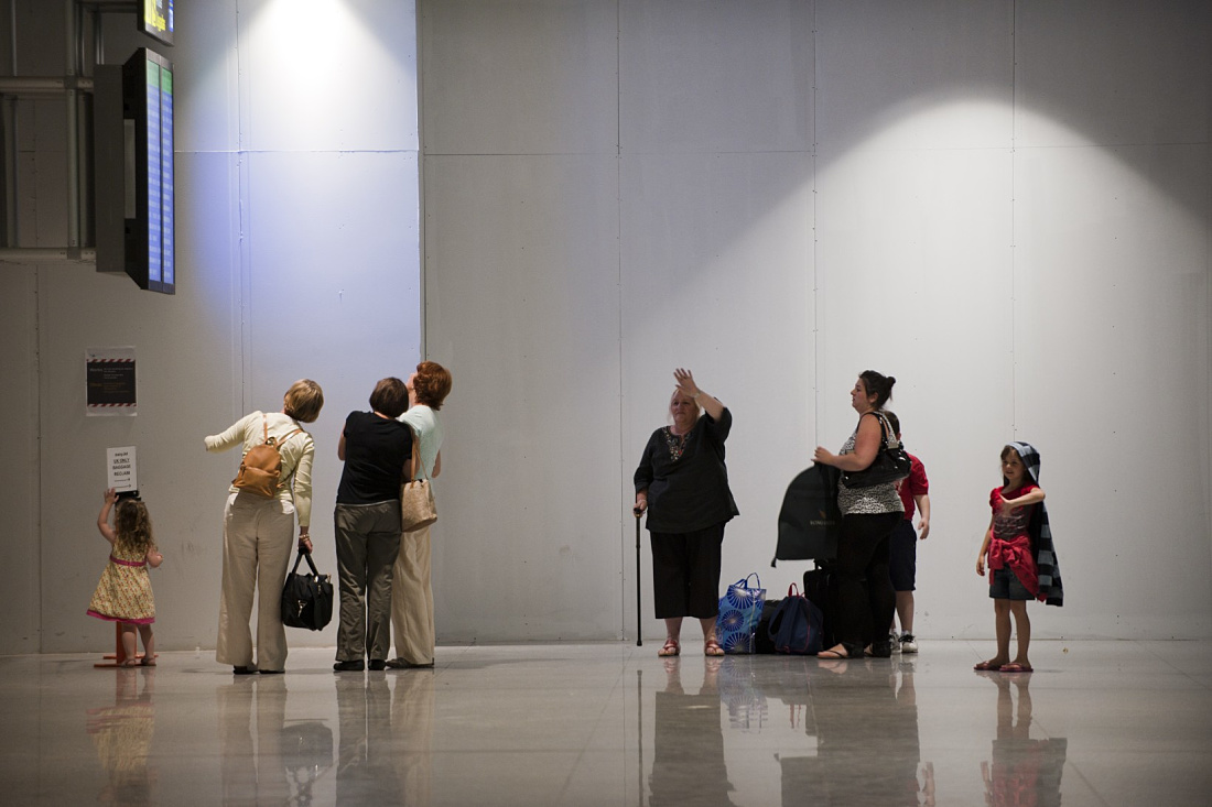 Malaga Airport Terminal 3: Travelers under ERCO downlights, ensuring efficient visual comfort.
