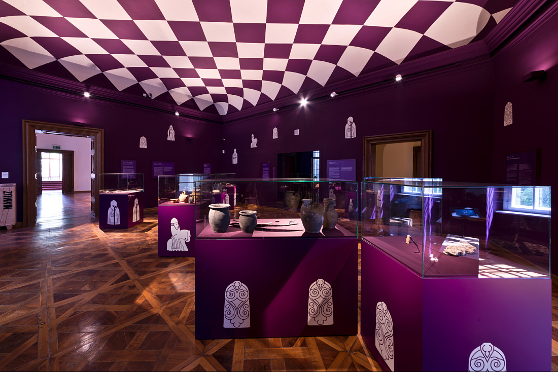 Interior of the MAMUZ Museum Mistelbach featuring archaeological exhibits in display cases and unique lighting.