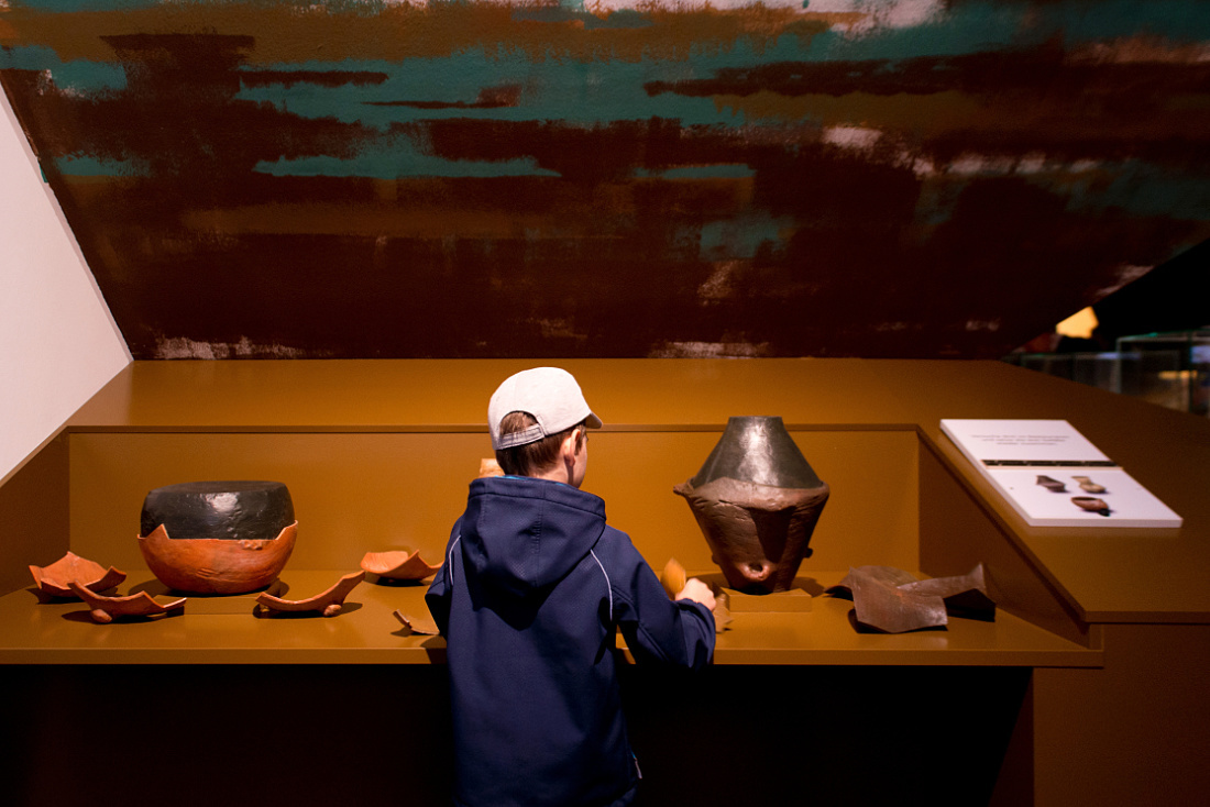 Boy interacts with archeological exhibits at the MAMUZ Museum, Mistelbach.
