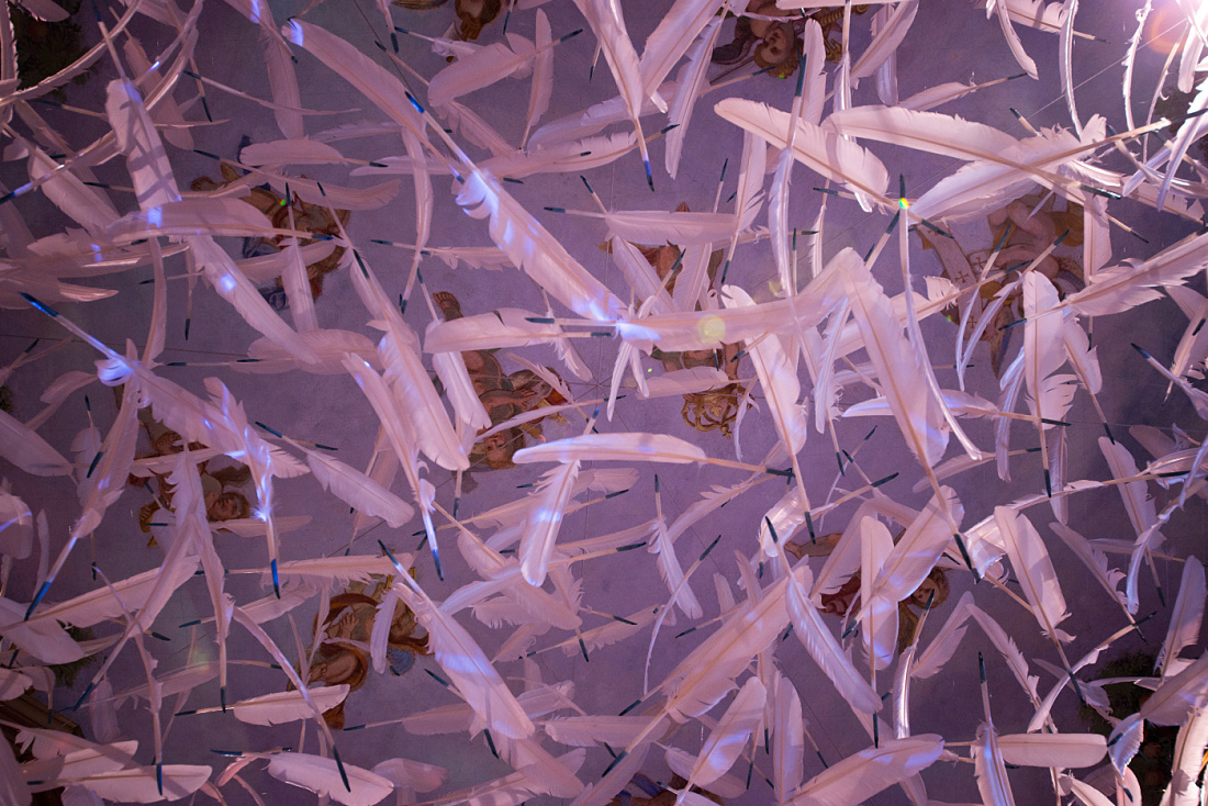 Illuminated feather installation at MAMUZ Museum, Mistelbach, creating a light and airy atmosphere.