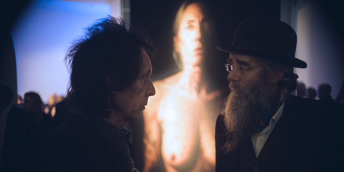 Exposición Matthew Penn: visitantes observan un retrato iluminado, acentuado con iluminación ERCO.