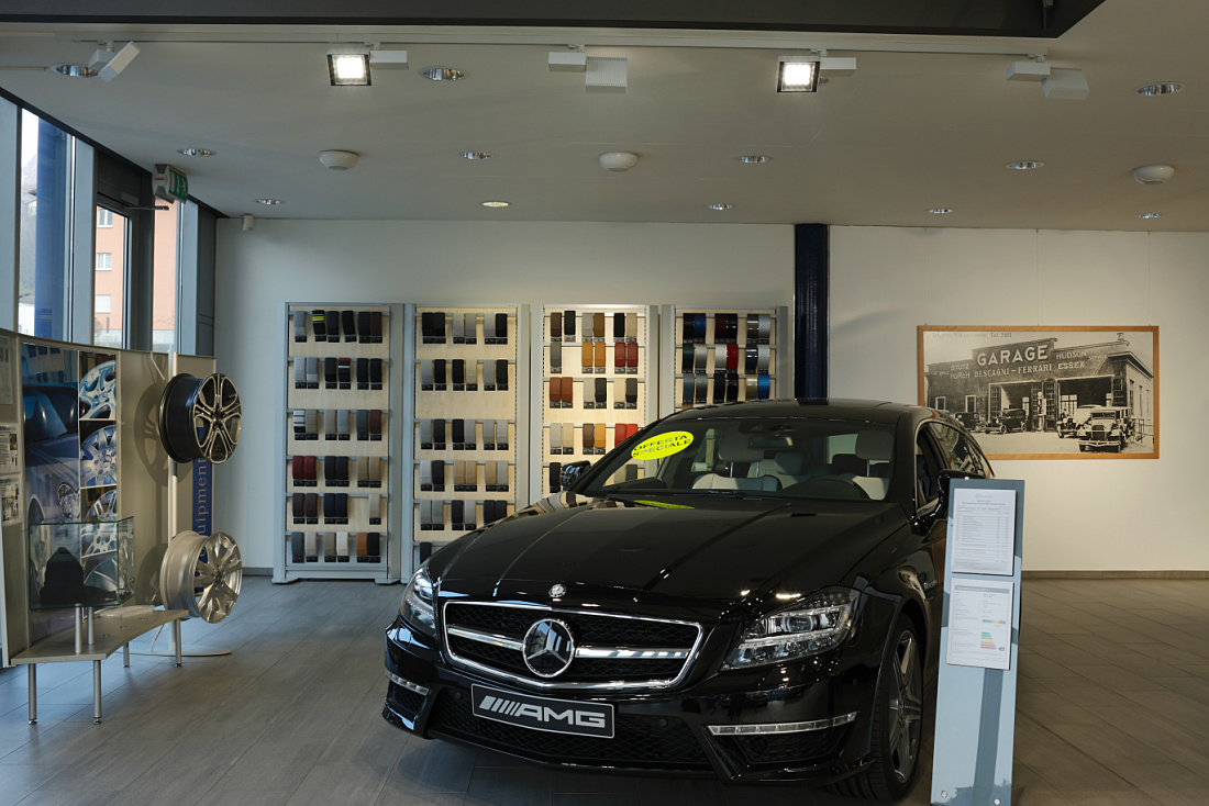 Mercedes showroom in Lugano featuring ERCO LED lighting for natural vehicle presentation.