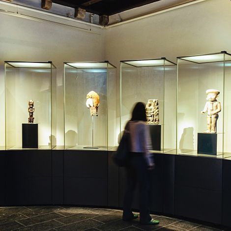 Illuminated display cases at Museu de Cultures del Món, Barcelona, with ERCO Optec spotlights.