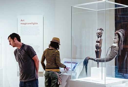 Visitors view artifacts in the Museu de Cultures del Món, illuminated by ERCO Optec and Pollux spotlights.