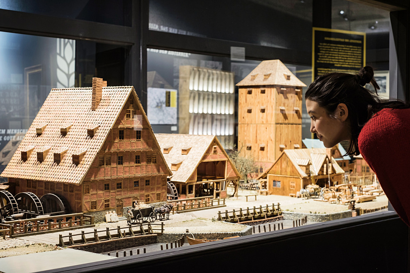 Una visitatrice osserva un modello di birrificio storico al Museum für Hamburgische Geschichte, illuminato con ERCO.