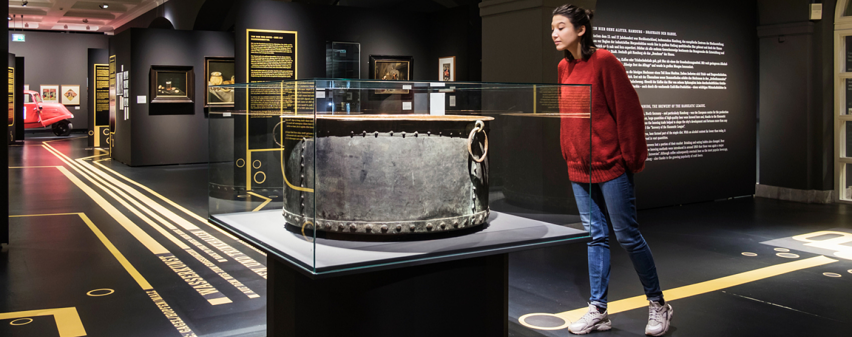 Brewing culture exhibit at Hamburg Museum featuring an old brewing kettle under ERCO accent lighting.