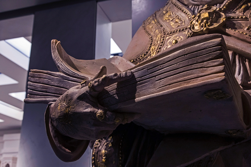 Sculpture of a saint with book, illuminated in Florence's Cathedral Museum.
