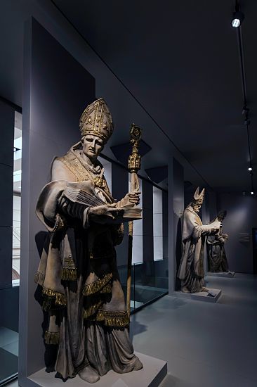 Illuminated bishop statues in Florence's Cathedral Museum, lit by ERCO lighting.